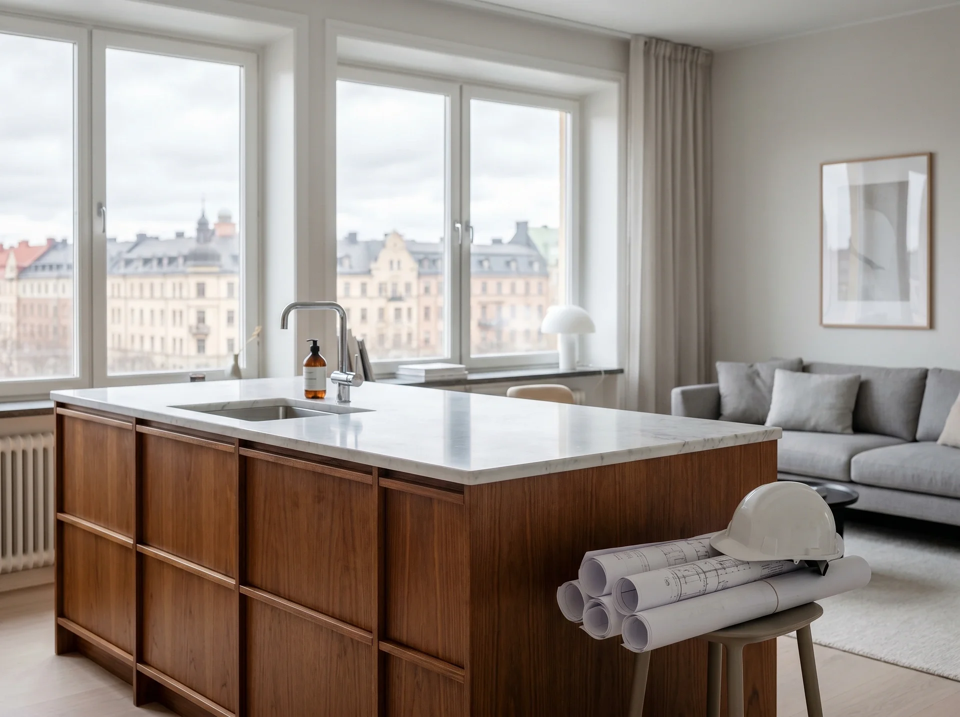Modernt kök med träö, marmorbänkskiva och byggritningar i förgrunden.